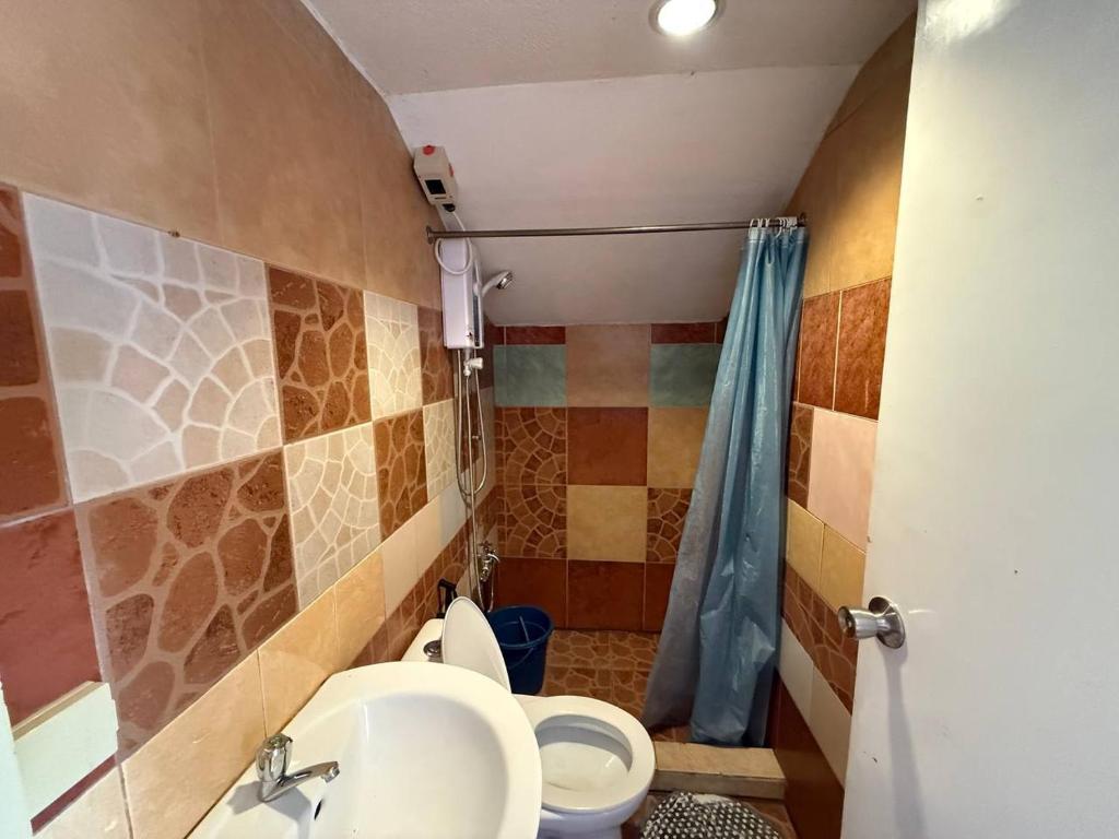 Tiled private bathroom with water heater and hot shower at Pecan Pension House